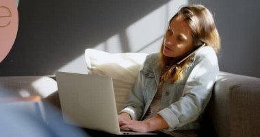 Atölye 4 k laptop kullanırken cep telefonda konuşurken kadın Takı Tasarımcısı