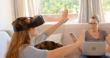 Lezbiyen çift sanal gerçeklik kulaklık ve dizüstü ev 4 k oturma odasında kullanma