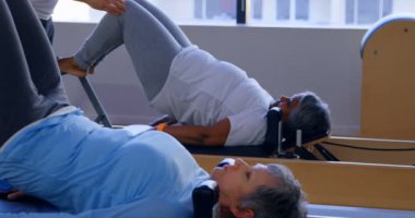 Yoga merkezi 4 k yoga yaparken üst düzey kadın talimat eğitmen