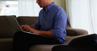 Ev 4 k kanepede dizüstü bilgisayar kullanan engelli adam