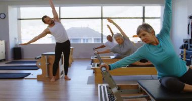 Grup yoga yoga merkezi 4 k yerine üst düzey kadın adamın talimat eğitmen