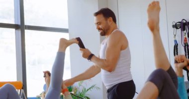 Yoga egzersiz germe sırasında yardımcı üst düzey kadın eğitmen 4 k Merkezi