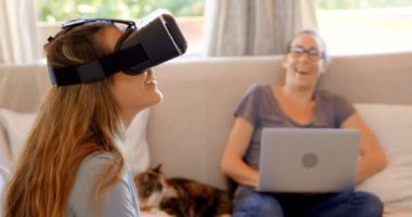 Lezbiyen çift sanal gerçeklik kulaklık ve dizüstü ev 4 k oturma odasında kullanma