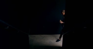 Üst katta 4 k taşırken cep telefonu kullanan adam silüeti