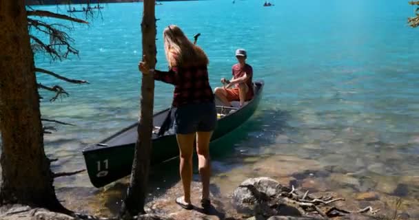 の田舎の川で手漕ぎボートの準備のカップル — ストック動画