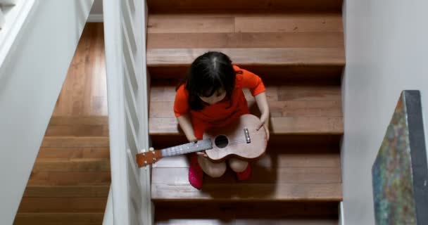 Girl Holding Guitar While Sitting Staircase Home — Stock Video