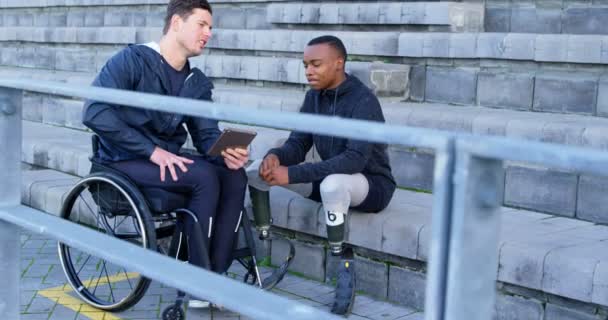 Zwei Behinderte Leichtathleten Diskutieren Über Digitales Tablet Sportstätte — Stockvideo