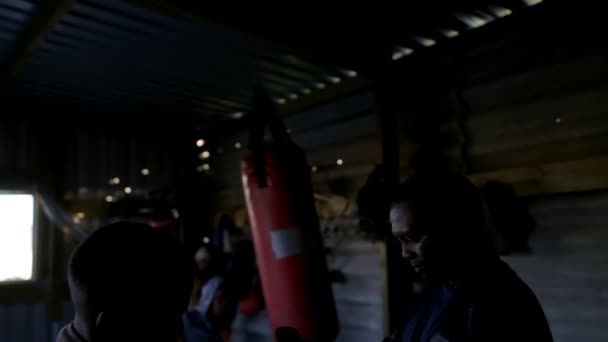 フィットネス スタジオ でボクシング グローブを着用の男性ボクサーを支援トレーナー — ストック動画
