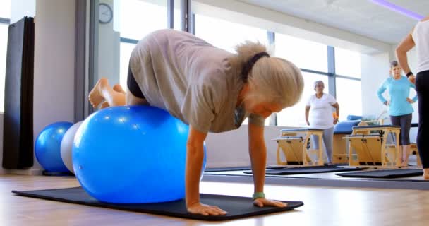 Senior Vrouw Trainen Met Uitoefening Van Bal Bij Yogacentrum — Stockvideo