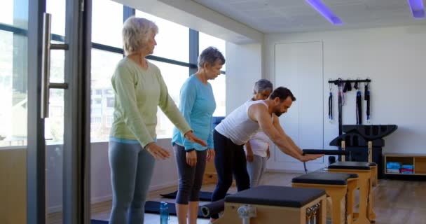 Tränare Hjälpa Äldre Kvinnor Att Utföra Yoga Yogacenter — Stockvideo