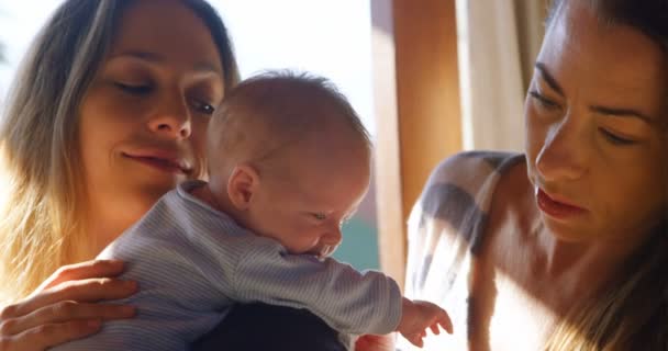 Lesbianas Pareja Sosteniendo Bebé Niño Casa — Vídeos de Stock