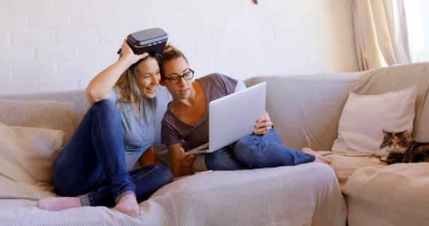女同性恋情侣使用笔记本电脑在客厅在家里4K — 图库视频影像
