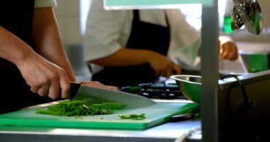 Restoranda 4k mutfakta Şef kesme sebzelerin orta bölüm