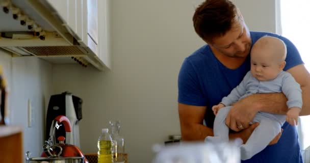 を自宅の台所で彼の男の子と一緒に遊んでの父 — ストック動画