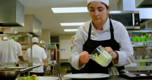Vrouwelijke Chef Kok Serveert Saus Een Bord Keuken — Stockvideo