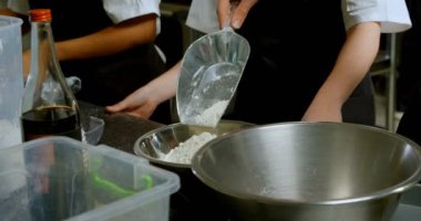 Erkek Şef mutfak tezgah üzerinde un dökme 