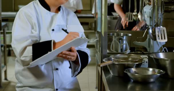 Chef Femenino Escribiendo Portapapeles Cocina — Vídeos de Stock