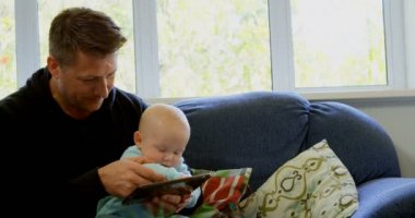Baba ve bebek çocuk dijital tablet oturma odasında ev 4 k kullanma.