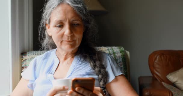 Seniorin Trinkt Kaffee Während Sie Ihr Handy Hause Benutzt — Stockvideo