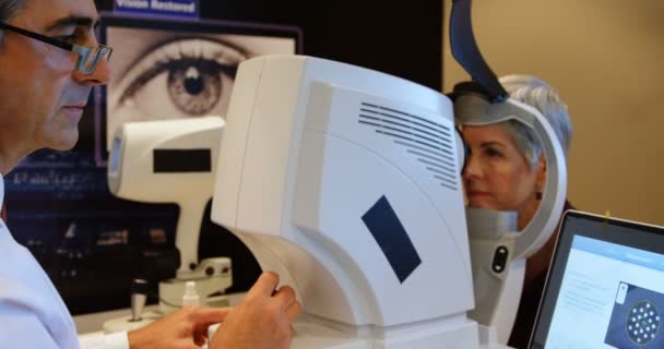 Optometrista Examinando Olhos Paciente Com Autorefratários Clínica — Vídeo de Stock