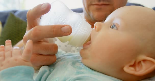 Vater Füttert Seinen Kleinen Jungen Heimischen Wohnzimmer Mit Milch — Stockvideo