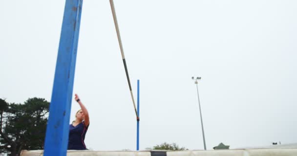 女性アスリート スポーツ会場 で高いジャンプを練習の低角度表示 — ストック動画