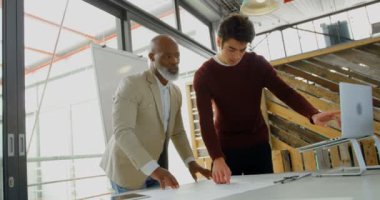 Erkek Yöneticiler dizüstü bilgisayar ve 4k ofis planı üzerinde tartışırken