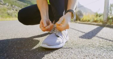 Kadın kıdemli kırsal 4 k bir yolda Ayakkabı bağcıklarımı ipe düşük bölümü