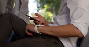 Otobüste seyahat ederken cep telefonuyla erkek banliyö orta bölümünde 