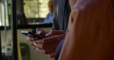 Birbirleriyle etkileşim otobüs durağında cep telefonu kullanırken çift 