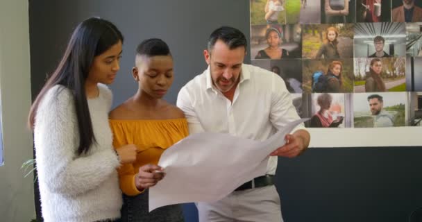 Equipo Diseñadores Gráficos Discutiendo Sobre Tabla Oficina — Vídeo de stock