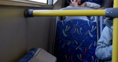 Kız otobüste seyahat ederken cep telefonuna müzik dinleme 