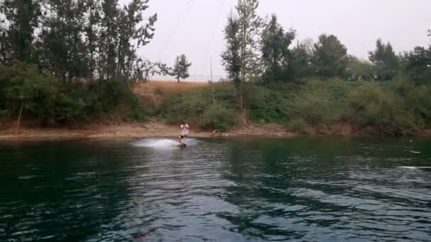 Νεαρός Άνδρας Wakeboarding Στον Ποταμό Μια Ηλιόλουστη Ημέρα — Αρχείο Βίντεο