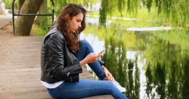 Güzel kadın cep telefonuyla Nehri yakınında 4 k