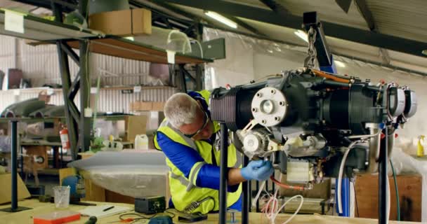 Чоловічий Інженер Ремонтує Авіаційний Двигун Ангарі — стокове відео
