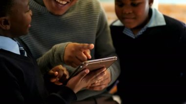 Erkek öğretmen okulda sınıfta öğrencilerle dijital tablet kullanma 