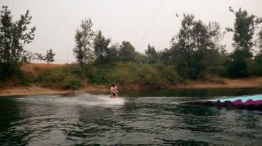 Genç adam wakeboarding nehre güneşli bir günde 4k 