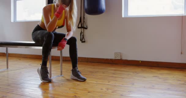 フィットネス スタジオ でリラックスした疲れの女性ボクサー — ストック動画