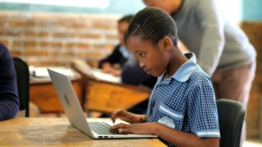 Okulda sınıfta dizüstü bilgisayar ve dijital tablet kullanan öğrenciler 