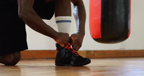 Unterteil eines männlichen Boxers, der Schnürsenkel im Fitnessstudio bindet 4k