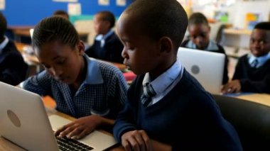 Okulda sınıfta dizüstü bilgisayar kullanan öğrenciler 