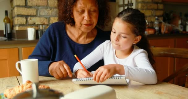 Chica Escribiendo Bloc Notas Con Abuela Cocina Casa — Vídeos de Stock