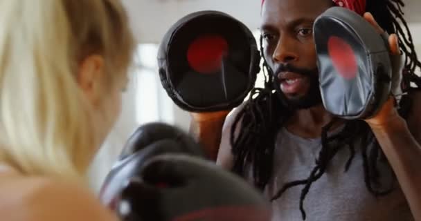 男性トレーナー トレーニング フィットネス スタジオ で女性ボクサー — ストック動画
