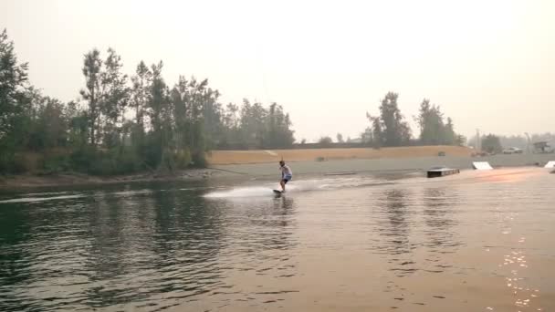 Νεαρός Άνδρας Wakeboarding Στον Ποταμό Μια Ηλιόλουστη Ημέρα — Αρχείο Βίντεο