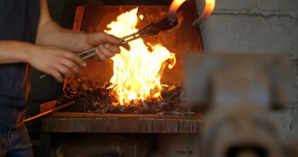 Partie médiane de fer à cheval de moulage de forgeron femelle dans l'usine. Concentrez-vous sur le fer à cheval chaud rayonnant .