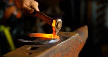 Parlayan sıcak at nalı fabrika kalıp metal Close-up. Bir çekiçle vurmak.