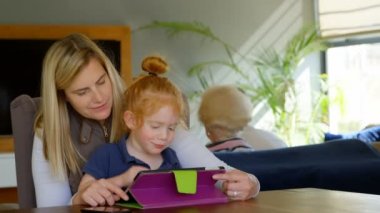 mutlu anne ve gülümseyen kızı evde dijital tablet kullanma yakın çekim. Aile birlikte yaşam tarzı zevk.