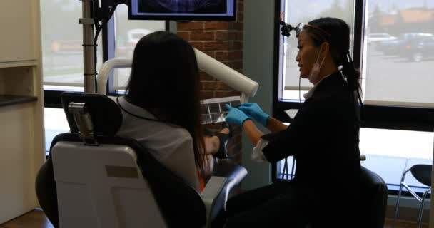 Panning Shot Pretty Female Asian Dentist Wearing Lab Coat Interacting — Stock Video