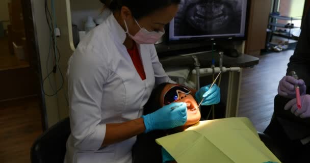 Panning Βολή Της Γυναικείας Ασίας Οδοντίατρος Εξετάζει Ένα Νεαρό Ασθενή — Αρχείο Βίντεο