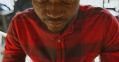 Önden görünüm yakın çekim yakışıklı adamın cep telefonu kafede sıcak bir içecek tadını çıkarırken kullanarak. Yavaş çekimde